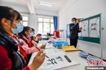 在轩辕小学，老师在教孩子们用毛笔书写“轩辕”二字。　赵亮 摄 - 中国新闻社河北分社