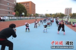 图为体育老师给同学们讲解轮滑动作要领。雷永怀 摄 - 中国新闻社河北分社