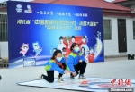 15日，东柏棠小学学生在中国新闻社“冰雪大篷车”巡回活动现场体验旱地冰壶乐趣。　翟羽佳 摄 - 中国新闻社河北分社