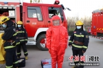 南宫市丰翼中学的学生在消防救援人员指导下体验使用消防器材。王林 摄 - 中国新闻社河北分社