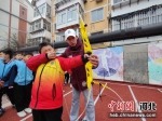 图为老师指导学生射箭。 贾思雨 摄 - 中国新闻社河北分社