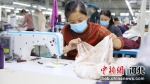 南宫市一家制衣厂内附近村庄的留守妇女正在加工服装。 田威 摄 - 中国新闻社河北分社