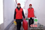 巨鹿县志愿者给南哈口村困难户送生活物品。 供图 - 中国新闻社河北分社