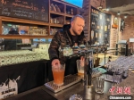 图为亨利在崇礼太舞滑雪小镇精酿工厂展示自己酿造的啤酒。　张帆 摄 - 中国新闻社河北分社