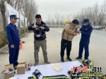 县消防大队工作人员指导微型消防站人员进行穿戴空气呼吸器。 供图 - 中国新闻社河北分社