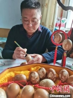 于迎年正在鸡蛋上进行雕刻。　何卫东 　摄 - 中国新闻社河北分社