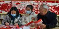 图为非遗传承人赵树谦正在教孩子们学习剪纸。 黄杉杉 摄 - 中国新闻社河北分社