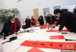 图为中国书画家在沧州盐山书写新春祝福书画作品。　石磊 摄 - 中国新闻社河北分社