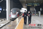 图为师徒两人在站台等列车到来与乘警进行交接工作。 - 中国新闻社河北分社