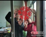 图为贴窗花。 朱晨玲 摄 - 中国新闻社河北分社