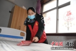 志愿者们为老人整理床铺。 王瑞辉 摄 - 中国新闻社河北分社