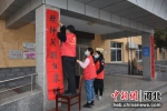 图为志愿者们在贴春联。 王瑞辉 摄 - 中国新闻社河北分社
