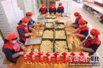 在河北省迁西县三屯营镇传统大集市场上，工人们正忙着制作年货“棋子火烧”。 顾大鹏 摄 - 中国新闻社河北分社