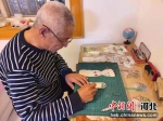 76岁的迁西民间艺人李文泽依然保持每日雕刻皮影的习惯。 作者 李少华 - 中国新闻社河北分社