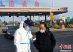 图为翟立(左)在首都环线高速公路固安南出口执勤，查验行程码。　受访者供图 - 中国新闻社河北分社