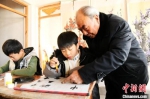 图为王魁士在辅导孩子们学习书法。　程学虎 摄 - 中国新闻社河北分社