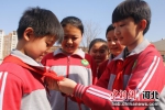 临西县第一小学一名学生在帮同学系红领巾。 何连斌 摄 - 中国新闻社河北分社