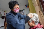 图为邯郸市邯山区志愿者马晓丽义务给老人做头部理疗。　李燊 摄 - 中国新闻社河北分社