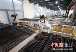 图为3月15日，在河北省固安县彭村乡一渔具生产车间，工人们正组装鱼竿。 吴迪 摄 - 中国新闻社河北分社