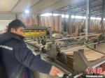 平乡县一家档案用品有限公司的工人正在进行纸板压制。　李超 摄 - 中国新闻社河北分社