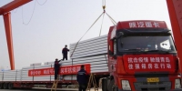 在文安县工业新区一工厂，工人正在吊运送往青岛莱西方舱医院的箱式房。　杜鹤 摄 - 中国新闻社河北分社