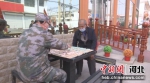 工作人员正在陪老人下棋。 张洁 摄 - 中国新闻社河北分社