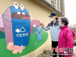 色彩明丽的垃圾分类宣传画吸引居民驻足观看。 - 中国新闻社河北分社