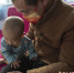张伟与医院护士通过手机视频在看望还在医院新生儿特护保温箱里的小儿子。 古轩 - 中国新闻社河北分社