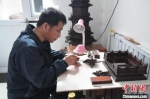 图为李长久正在制作的红木古建筑模型。　张艺典 摄 - 中国新闻社河北分社
