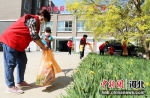 图为志愿者带小朋友一起拣拾脚下垃圾。 作者 刘巨雷 - 中国新闻社河北分社