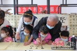志愿者教孩子们写书法。 袁野 摄 - 中国新闻社河北分社