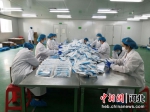 工人在打包医用外科口罩。 安国市委宣传部供图 - 中国新闻社河北分社