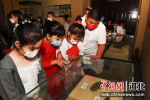 图为学生们近距离观看墓葬出土的铜镜文物。 作者 王占林 - 中国新闻社河北分社
