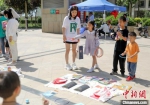 孩子们在“跳蚤市场”玩套圈游戏。　陈康 摄 - 中国新闻社河北分社