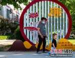 在枣强县廉洁文化广场，一位老人带着孩子从廉洁文化展牌前走过。 李金刚 - 中国新闻社河北分社