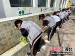 石家庄鹿泉区寺家庄小学学生正在手洗红领巾。 刘蓉菲 摄 - 中国新闻社河北分社