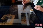 图为裴小苓正在勾勒玻璃油画线条。　王晖 摄 - 中国新闻社河北分社