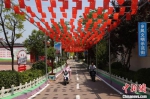 祁村村民骑电动车行走在干净整洁、绿树成荫的街道。　高晓博 摄 - 中国新闻社河北分社