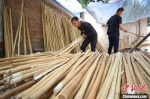 图为一家蜡杆加工厂内，工人们正在对蜡杆按品质进行分类、挑选。　贾珺 摄 - 中国新闻社河北分社