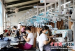 图为河北省肃宁县一家针纺企业加工车间内，员工正在加紧赶制订单。 刘巨雷 摄 - 中国新闻社河北分社