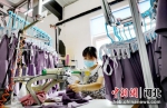 图为河北省肃宁县一家针纺企业加工车间内，员工正在加紧赶制订单。 刘巨雷 摄 - 中国新闻社河北分社