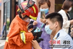 图为消防员为小朋友穿上消防服。 孙宝宇 摄 - 中国新闻社河北分社