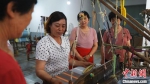 图为张苗芳(左二)现场传授织布技艺。　贾佳贤 摄 - 中国新闻社河北分社
