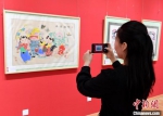 在河北武强年画博物馆展厅内，参观者在对绵竹木版年画拍照留念。　苏小立 摄 - 中国新闻社河北分社