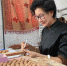 图为河北省三河市核雕手艺人王晓燕在工作台前雕刻。　高澍 摄 - 中国新闻社河北分社