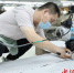 图为工人在在沧东经济开发区一家服装企业裁剪服装。 田博 摄 - 中国新闻社河北分社