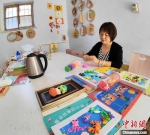 张美正在准备给孩子们讲故事用的道具。　夏晓婷 摄 - 中国新闻社河北分社