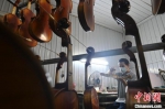 图为武强乐器工人黄国权在为小提琴上漆。　翟羽佳 摄 - 中国新闻社河北分社