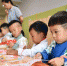 雄安新区容东片区的雄安容和乐安幼儿园里，小朋友们身着中式服装制作灯笼。　韩冰 摄 - 中国新闻社河北分社