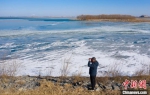 春节期间，李国忠在湖心路上观察湖面结冰情况。　陈康 摄 - 中国新闻社河北分社